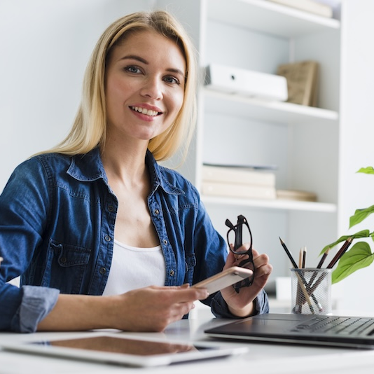 blond-working-woman-holding-smartphone-glasses