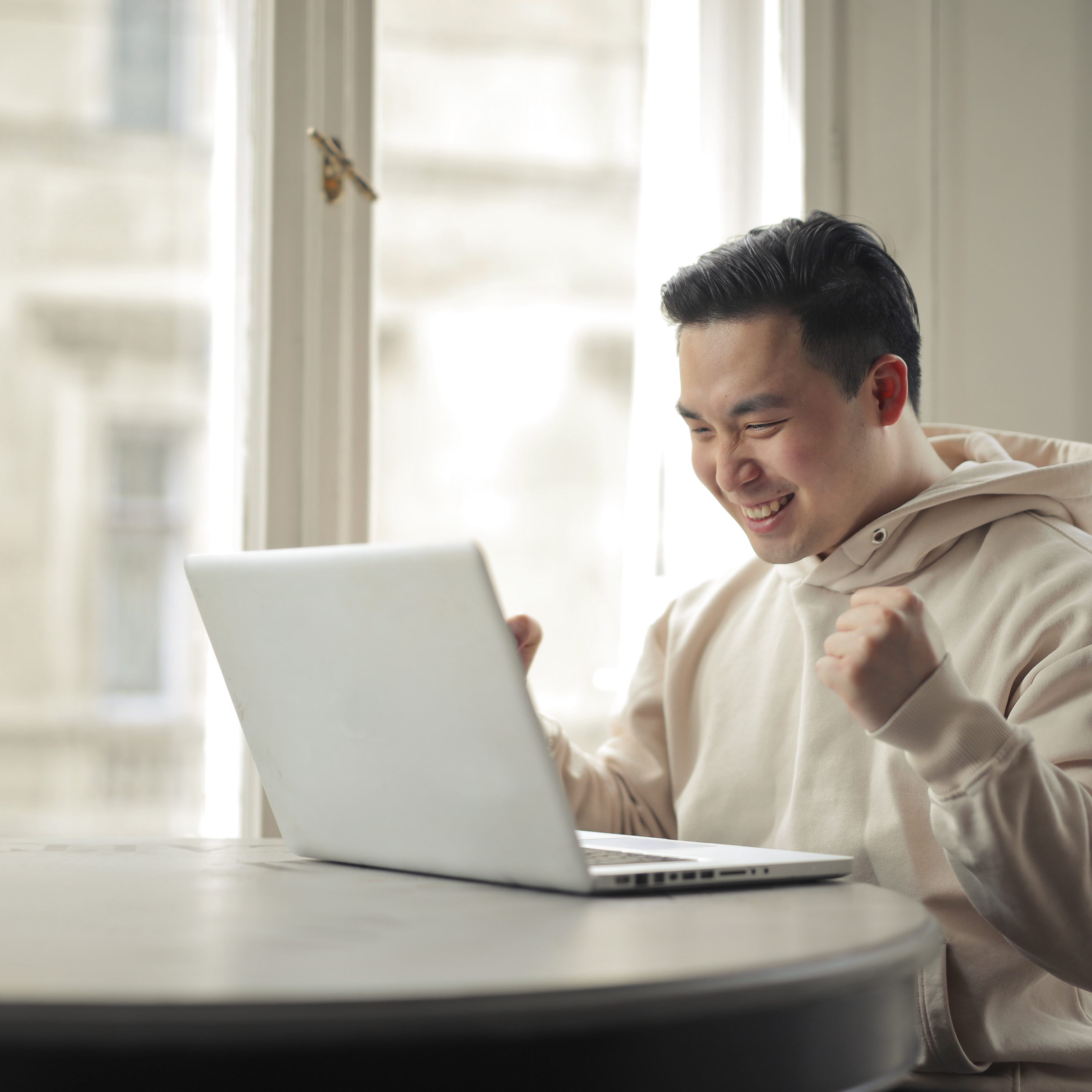 young man rejoices happy in front of a computer